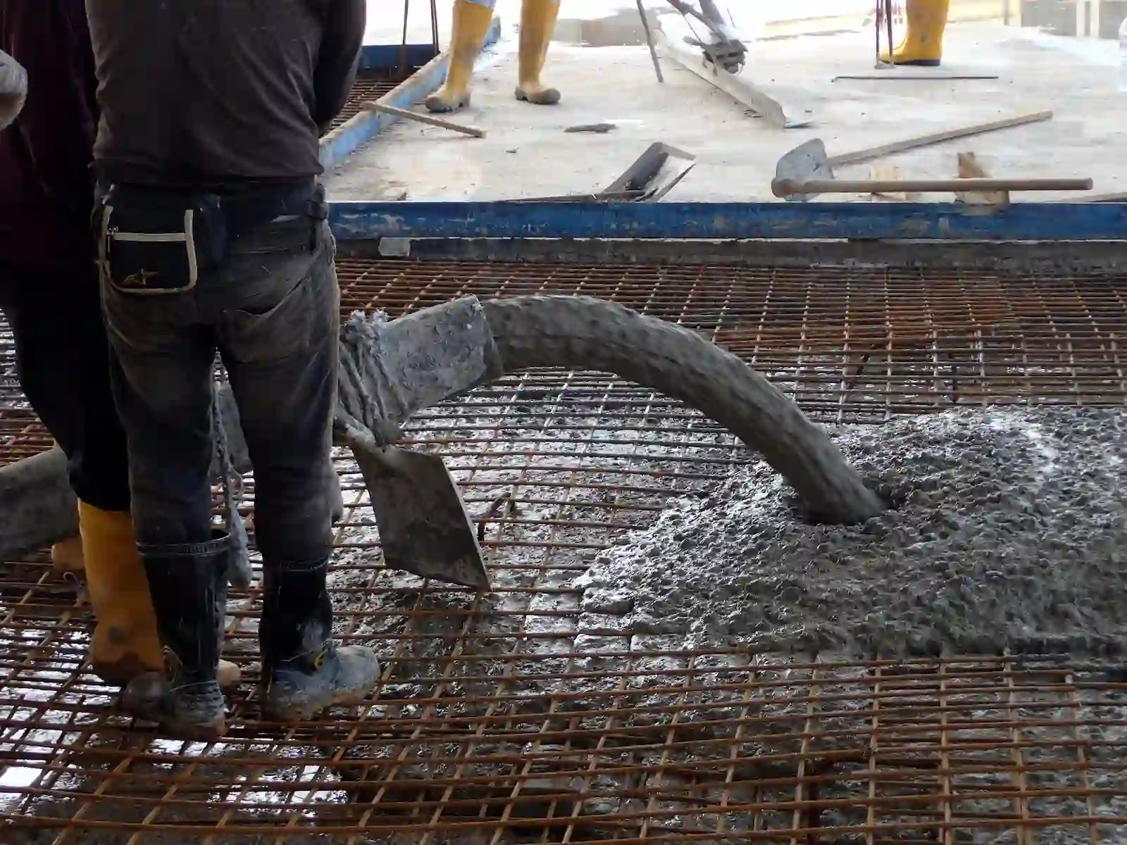 Obreros instalando la malla ACMA y preparando la mezcla de hormigón
