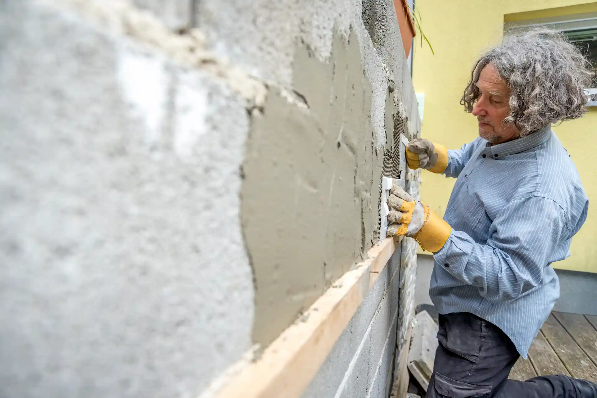 albañil jobbing estucando pared exterior