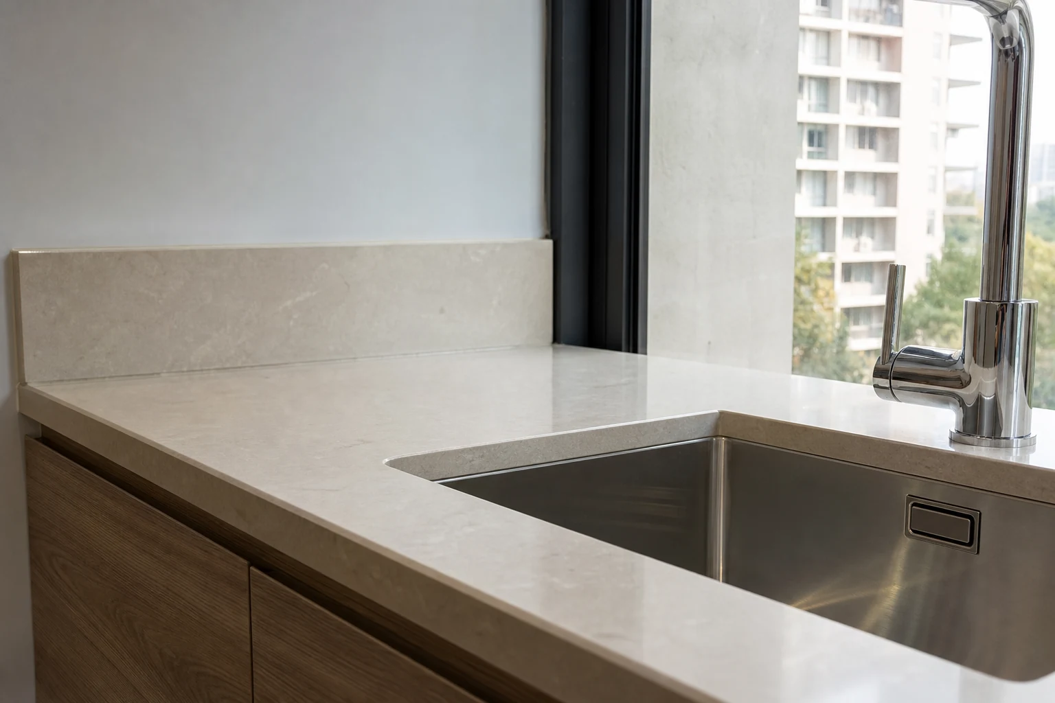 Detalle de unión y sellado de cubierta de cocina junto a un lavaplatos bajo cubierta
