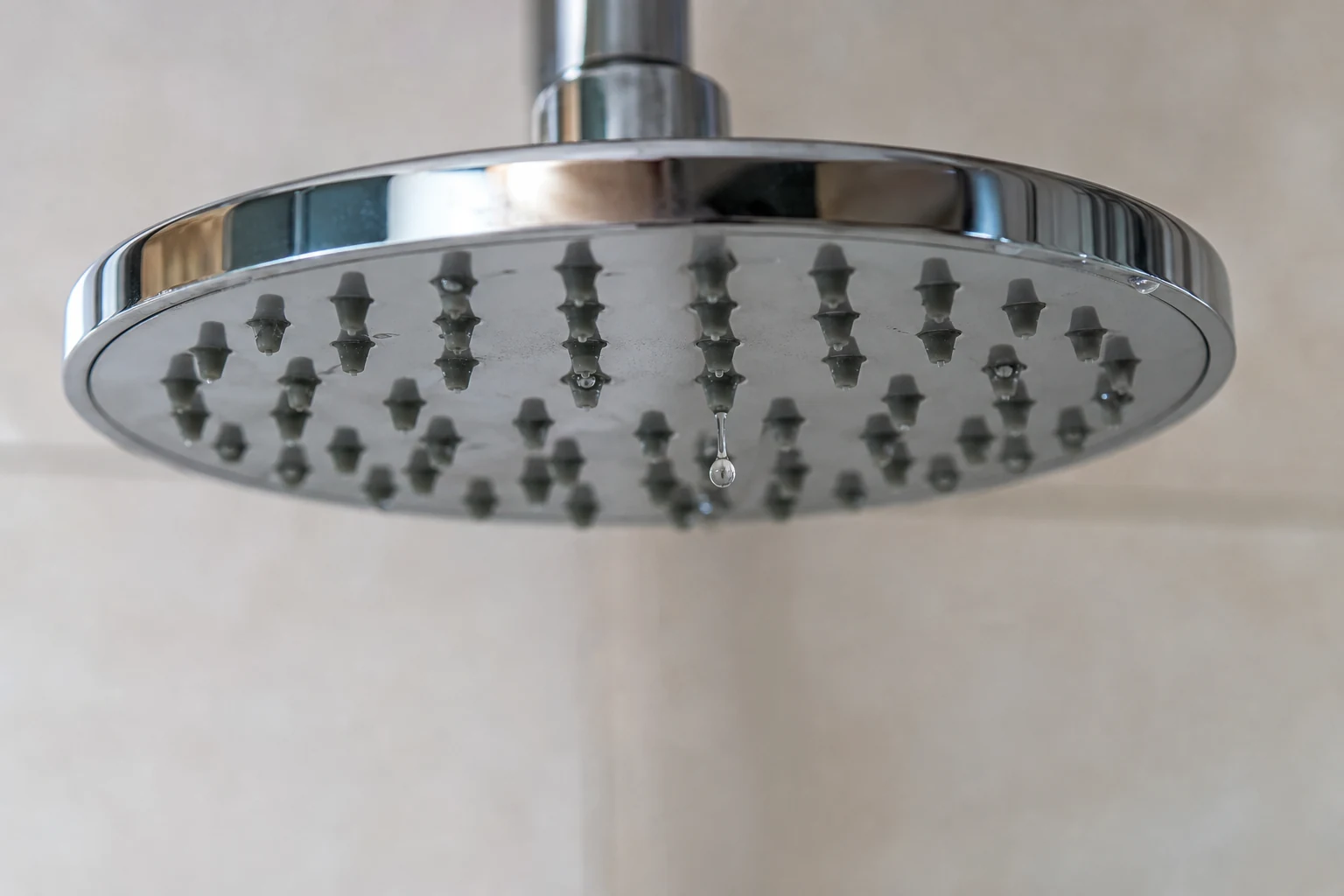 Detalle de una gota en el rociador de ducha para identificar desde dónde sale el agua