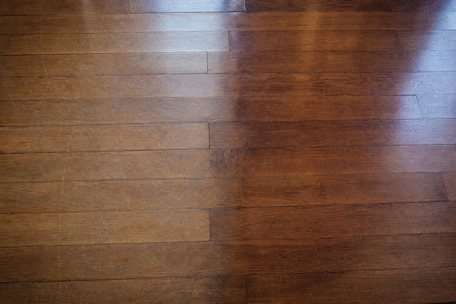 Detalle de rayas superficiales y desgaste de la terminación en un piso de parquet
