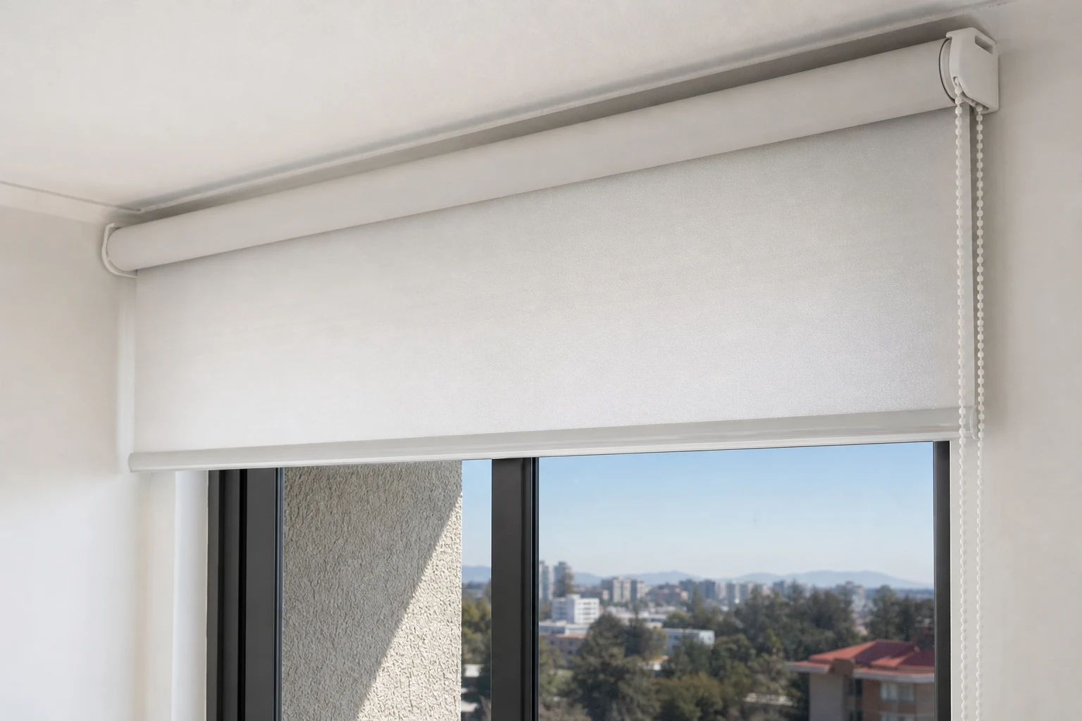 Detalle de una cortina roller instalada sobre el marco con soportes alineados y apertura de ventana libre
